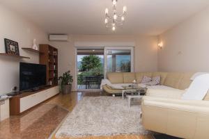 a living room with a couch and a tv at Holiday Home Vele with pool in Vrgorac