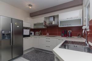 a kitchen with a stainless steel refrigerator and a sink at Holiday Home Vele with pool in Vrgorac