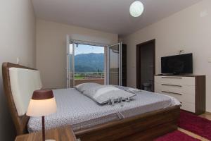 a bedroom with a bed with a television and a window at Holiday Home Vele with pool in Vrgorac +31 photos