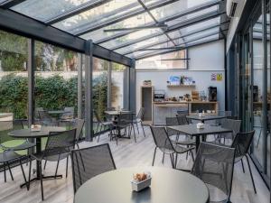 a restaurant with tables and chairs and windows at Ibis Budget Madrid Centro Lavapies in Madrid