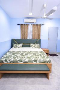 a bed in a room with a blue wall at Villa Sahel in Niamey