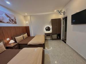a small room with two beds and a television at 1 House 2 in Da Lat +55 photos