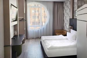 a hotel room with a bed and a window at Garner Hotel Bremen City by IHG in Bremen