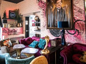 ein Wohnzimmer mit einem lila Sofa und einer Ziegelwand in der Unterkunft ibis Styles Lausanne Center MadHouse in Lausanne