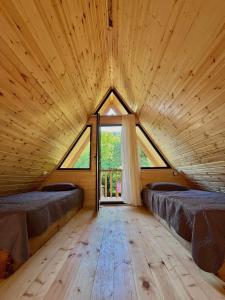 a room with two beds in a wooden room with a window at Lakarido in Tsesi