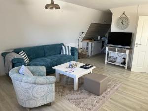 a living room with a blue couch and a table at Boddenhaus Darss in Wieck
