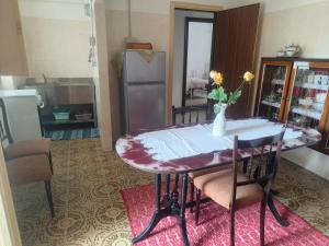 a dining room table with a vase of flowers on it at Oasi Relax Lago Omodeo Casa Demartis in Tadasuni