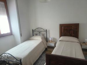 a bedroom with two beds and a window at Oasi Relax Lago Omodeo Casa Demartis in Tadasuni