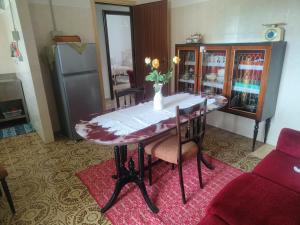 a dining room table with a vase of flowers on it at Oasi Relax Lago Omodeo Casa Demartis in Tadasuni