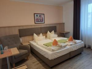a bedroom with a large bed and a chair at Rathausstuben in Wackersdorf +57 photos