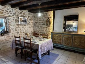 a dining room with a table and a kitchen at Gîte campagne et clim - 4 pers. - FR-1-489-84 in Saint-Bonnet-Tronçais