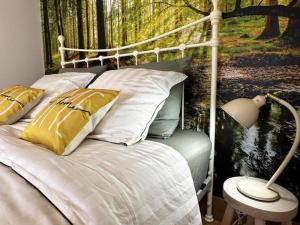 a bedroom with a bed with a painting of a forest at Gîte campagne et clim - 4 pers. - FR-1-489-84 in Saint-Bonnet-Tronçais