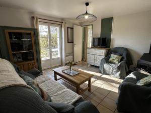 a living room with a couch and a coffee table at Gîte campagne et clim - 4 pers. - FR-1-489-84 in Saint-Bonnet-Tronçais