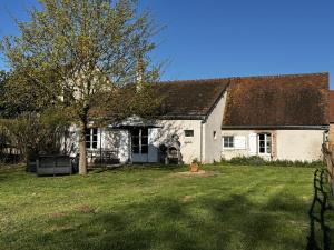 a white house with a tree in the yard at Gîte campagne et clim - 4 pers. - FR-1-489-84 in Saint-Bonnet-Tronçais