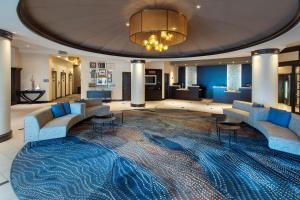a hotel lobby with blue chairs and a large rug at Marriott Philadelphia West in West Conshohocken