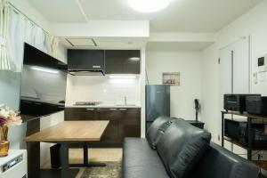 a living room with a leather couch and a table at Laguna Verde Misono 103 in Sapporo