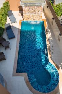 an overhead view of a swimming pool with blue water at Mhonsa Hotel in Chiang Mai