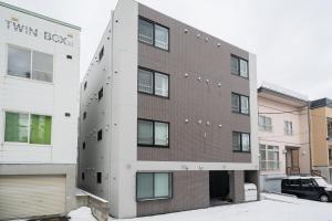 a brick building with a car parked in front of it at Laguna Verde Misono 103 in Sapporo
