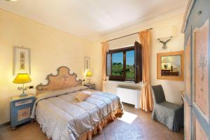 1 dormitorio con cama, ventana y silla en Relais Il Canalicchio Country Resort & SPA, en Canalicchio