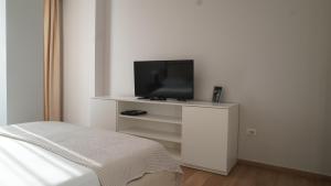 a bedroom with a tv on a white dresser at Hotel Miami II in Golem