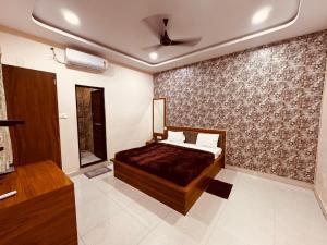 a bedroom with a bed and a wall at Hotel shri Sudama in Ambikāpur