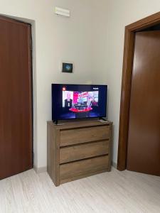 a flat screen tv sitting on top of a wooden dresser at B&B Fiume in Morino