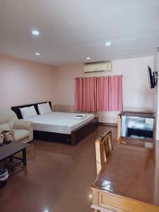 a living room with a bed and a couch at โรงแรมโกลเด้นอินน์ in Chachoengsao