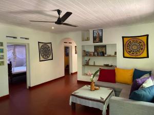 a living room with a couch and a ceiling fan at R&N Yellow House in Hikkaduwa
