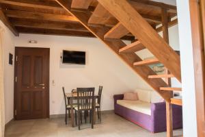 a staircase in a living room with a table and chairs at To Mpalkoni in Chorefto