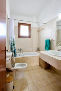 a bathroom with a toilet and a tub and a sink at Zeusplace Lemon Villa in Korinos +22 photos