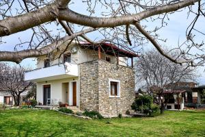 a building with a tower on top of a grass field at Zeusplace Lemon Villa in Korinos