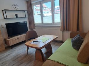 a living room with a coffee table and a television at Rathausstuben in Wackersdorf