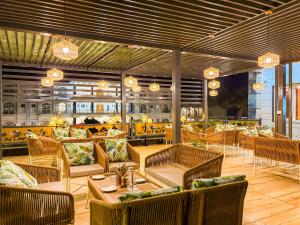 a restaurant with couches and tables and chairs at The Lychee Hotel & Resort by The Altruist in Rāmnagar