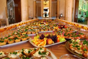 una larga mesa llena de muchos platos de comida en INTOURIST Hotel, en Volgograd