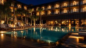 a hotel with a swimming pool at night at Taghazout Palm Hotel in Taghazout