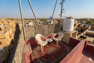 two chairs sitting on a balcony overlooking a city at Third eye view hotel and hostel in Jaisalmer +36 photos