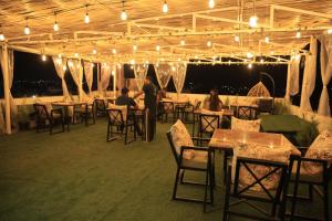 a group of people sitting at tables in a restaurant at Hotel Krishna Residency in Udaipur