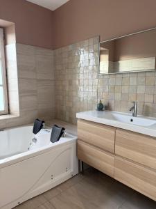 ein Badezimmer mit Badewanne und Waschbecken in der Unterkunft leon in Landerneau