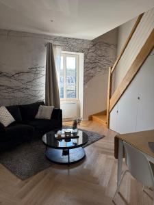 ein Wohnzimmer mit Sofa und Tisch in der Unterkunft leon in Landerneau