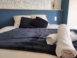 ein Bett mit Handtüchern und Kissen darauf in der Unterkunft leon in Landerneau + 2 Fotos