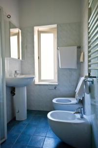 łazienka z umywalką, toaletą i oknem w obiekcie Francesca House w Pizie