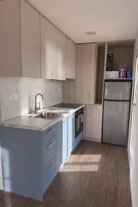 a kitchen with white cabinets and a sink and a refrigerator at Mobile Homes Gasperino in Pirovac +8 photos