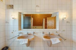 a bathroom with two sinks and a mirror at Ferienwohnung Ettenheim in Ettenheim +11 photos