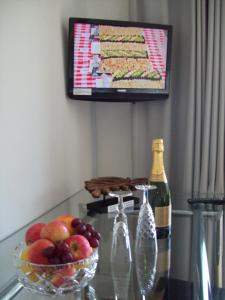 a glass table with a bottle of wine and a bowl of fruit at WILLOW BARN boutique B&B in Worle