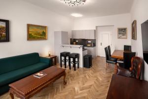 a living room with a green couch and a table at BHG Apartments Prague in Prague +60 photos