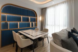 a dining room with a table and chairs and a couch at Above Element Bangtao Phuket by Arthouse Collection in Laguna Phuket