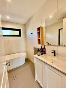 a bathroom with a tub and a sink and a bath tub at Williamstown Village 2 in Williamstown +19 photos
