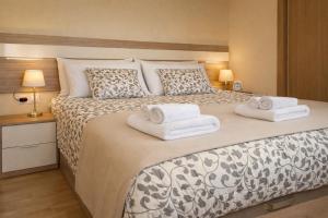 a bedroom with a large bed with towels on it at Nova MSuites Catedrales in Foz +5 photos