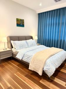 a bedroom with a bed with blue curtains at Williamstown Village 2 in Williamstown