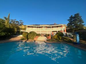 a large house with a swimming pool in front of it at Innisfree Manor in Somerset West